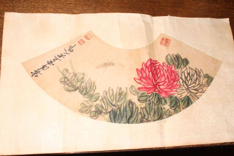 Qi Bashi, fan shaped watercolour of a chrysanthemum, having three seal stamps, unframed, 35cm by 63cm overall.