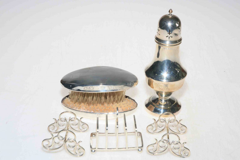 Silver caster, Birmingham 1960, pair Victorian silver carver rests, Birmingham 1897, silver five bar toast rack, Birmingham 1942, and pair silver backed brushes (4).
