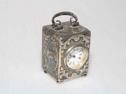 William Comyns silver boudoir clock, having embossed decoration and with...