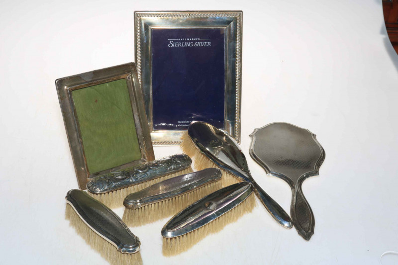 Two silver mounted easel photograph frames, together with silver backed hand mirror and brushes (8).