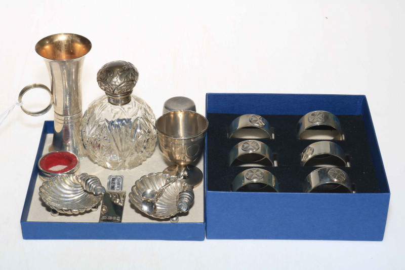 Silver items comprising set of six napkin rings, two spirit measure, egg cup, shell salts, note holder and scent bottle (8).