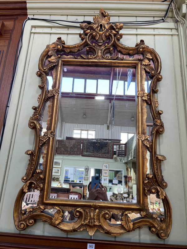 Ornate gilt framed marginal wall mirror, 127cm by 72.5cm.