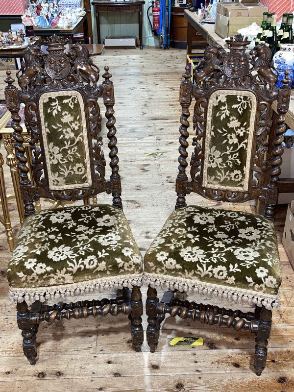 Pair Victorian carved oak side chairs with armorial crests.