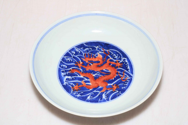 Chinese porcelain blue and white saucer dish decorated with internal red dragon, Qianlong mark to base, 18.5cm diameter.