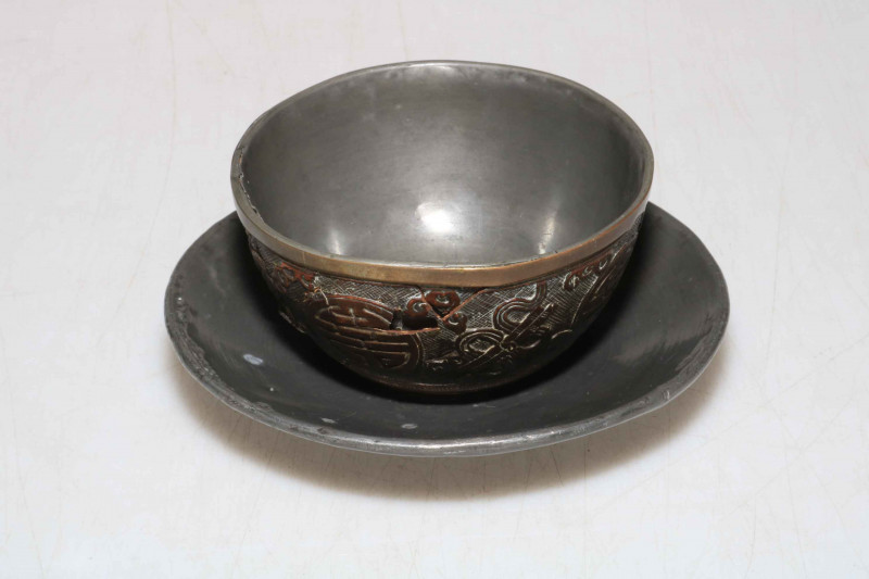 Chinese 19th Century hardwood cup and saucer decorated with Buddhist objects.