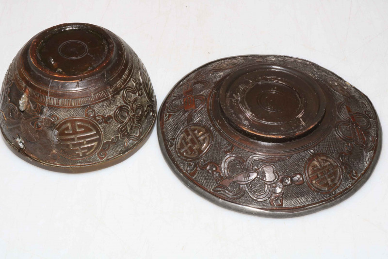 Chinese 19th Century hardwood cup and saucer decorated with Buddhist objects.
