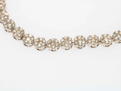 Spectacular diamond tennis bracelet in white gold and having 32 florets of seven brilliant cut diamonds, 18cm length. thumbnail
