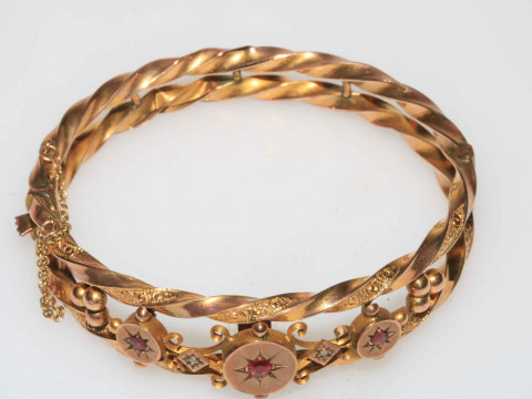 Edwardian 9 carat gold bangle of ornate form and set with three rubies,...