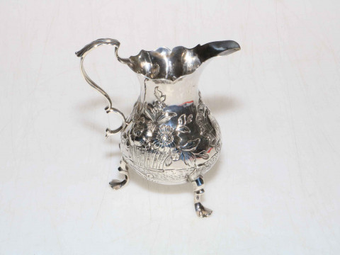 George III silver cream jug embossed with flowers, fruit and cartouche,...