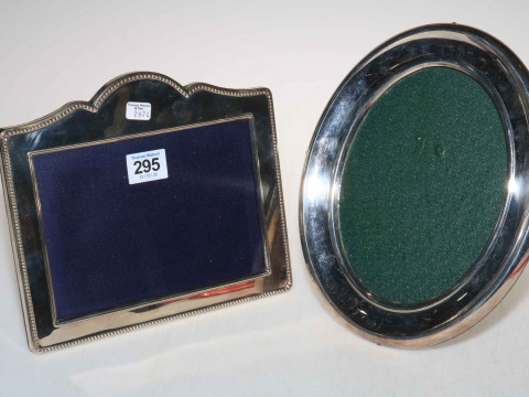 Two large silver easel photograph frames, the oval one 24.5cm high.