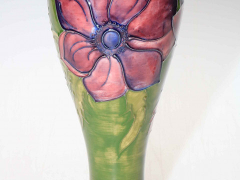 Moorcroft tall vase decorated with anemone on green ground, 28cm high.