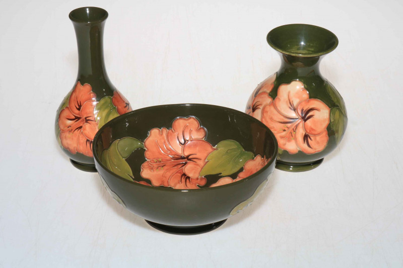 Moorcroft bowl, 8cm, vase, 14cm, and stemmed vase, 16cm, decorated with hibiscus design on green ground.