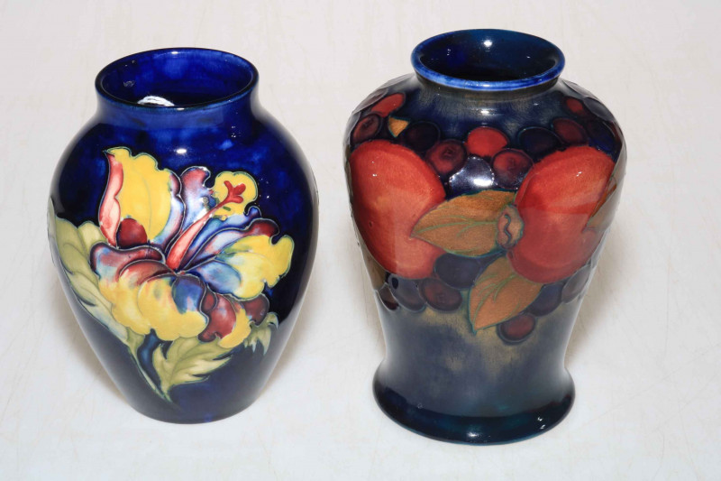 Moorcroft vase decorated with fruits on blue ground, 14cm high, with box, and a Moorcroft vase with hibiscus design on blue ground, 12cm high.
