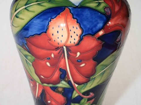 Moorcroft vase decorated with hibiscus design on blue and cream ground,...