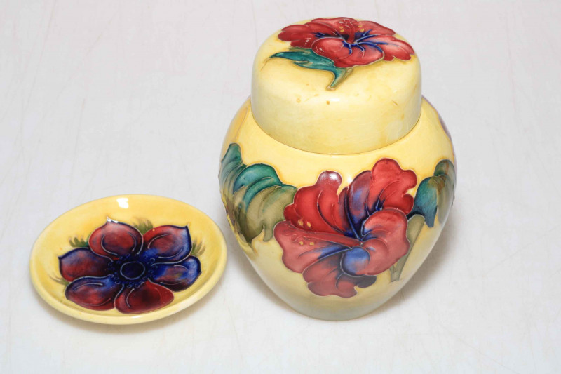 Moorcroft ginger jar decorated with hibiscus design on yellow ground, 12cm, and a Moorcroft pin tray decorated with anemone on yellow ground, 8cm diameter.