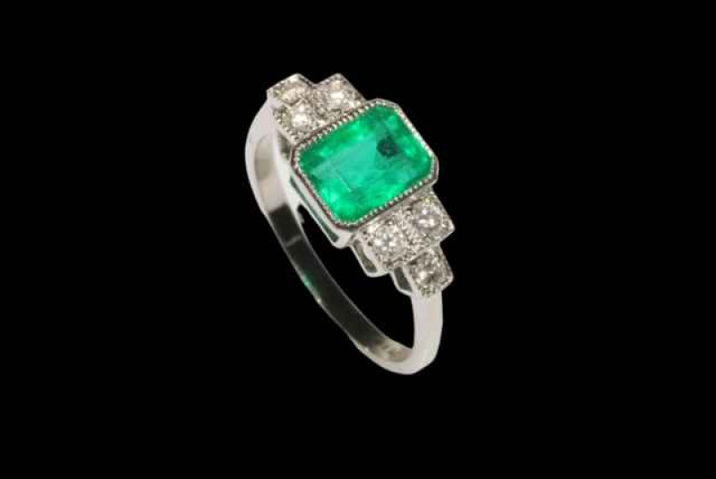 Emerald and diamond platinum ring, having approximately 1.25 carat emerald flanked by six brilliants, size M.