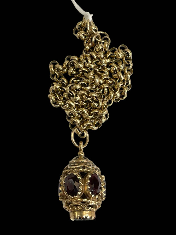 9 carat gold chain necklace with garnet set pendant.