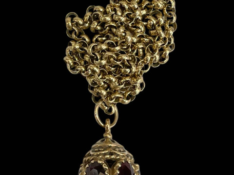 9 carat gold chain necklace with garnet set pendant.