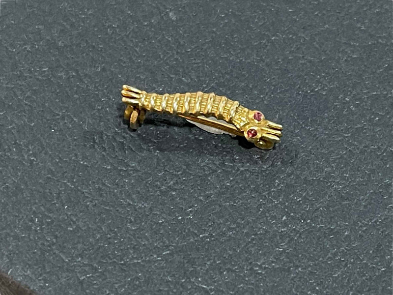 A WWII caterpillar club brooch in gold?, ruby/garnet cabochon set eyes, engraved to the reverse 'P/L. J. P. KELLY', with a secured pin clasp. Pilot unknown, no such record. No certificate.