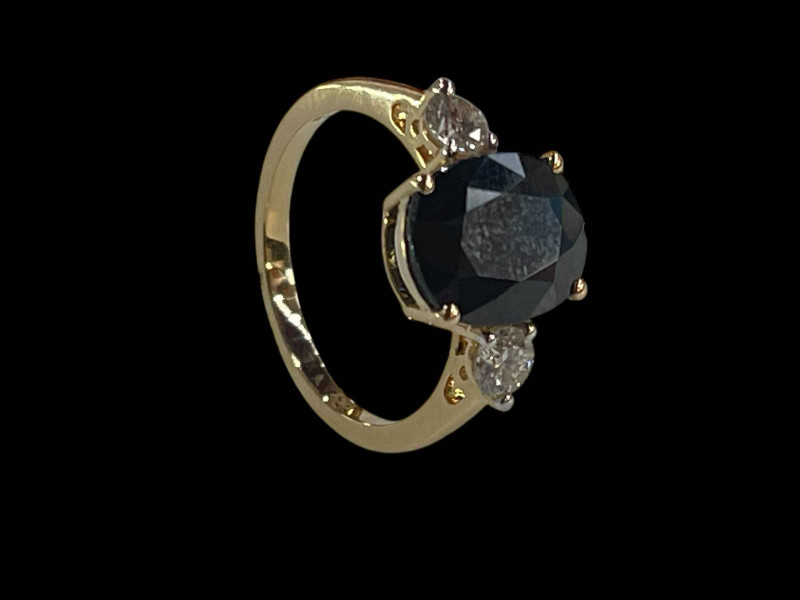 Sapphire and diamond three stone ring set in 18 carat yellow gold, the oval sapphire 2.75 carats flanked by diamonds totalling 0.38 carats, size L.