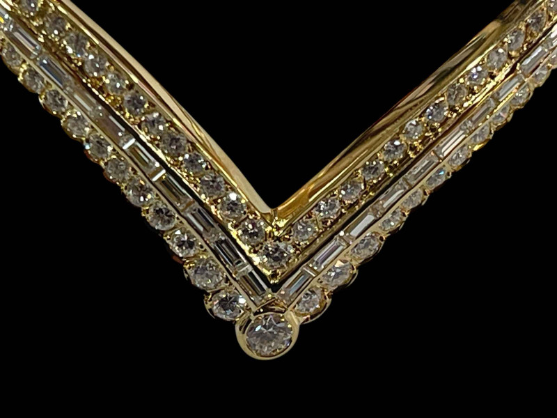 Diamond 'V' shaped bangle set with central row of baguette cut diamonds flanked by rows of brilliant cut diamonds in 18 carat yellow gold, diamonds 3 carats.