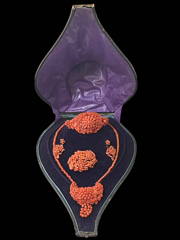 Cased parure of coral jewellery with necklace, bracelet, brooch and earrings.