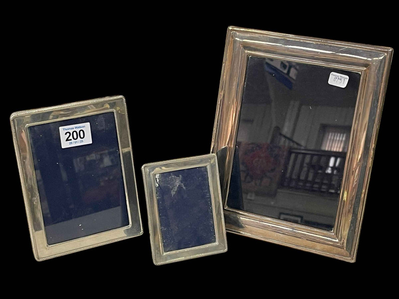 Three silver photograph frames.