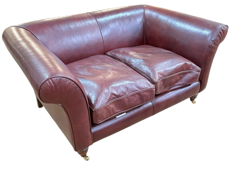Brown leather two seater settee on turned legs, 72cm by 150cm by 98cm.