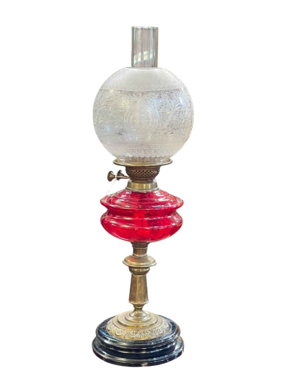 Victorian brass oil lamp with red glass reservoir and etched glass shade.