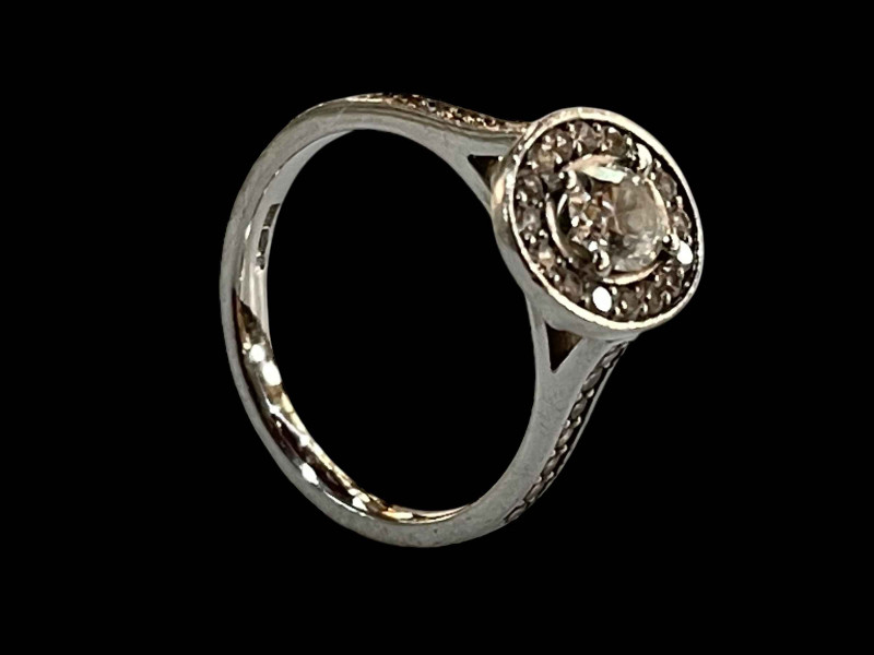 Platinum and diamond cluster ring, the central oval diamond 0.48 carats bordered by sixteen brilliant cut diamonds and further fourteen set into the shoulders, total diamond weight 0.90 carats, size K.