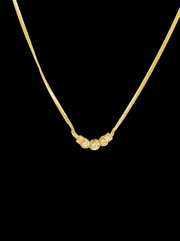 14 carat gold necklace set with three diamonds.