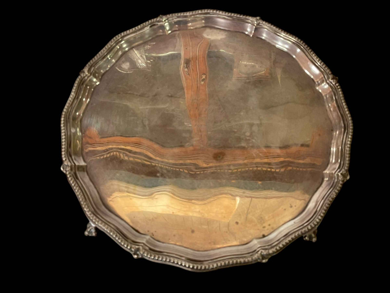 Silver salver on ball and claw feet, London 1928, 31cm diameter.