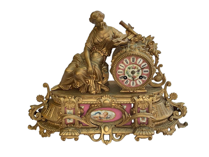 Ornate Continental gilt mantel clock decorated with pink porcelain panels and face.