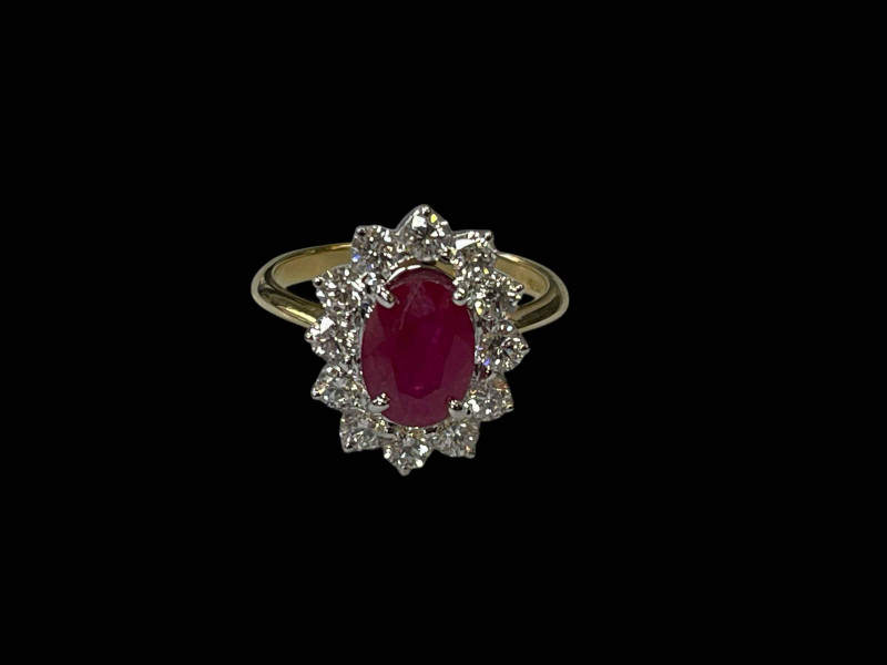 18 carat yellow and white gold oval ruby and diamond cluster ring, the 2.20 carat oval ruby surrounded by twelve diamonds totalling 0.80 carats, size P.