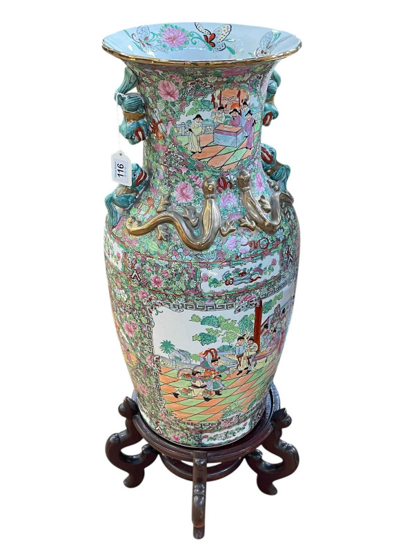 Large pair of floor standing Cantonese famille rose vases with decorated panels on floral ground each on six footed wooden stands, 86cm including stand.