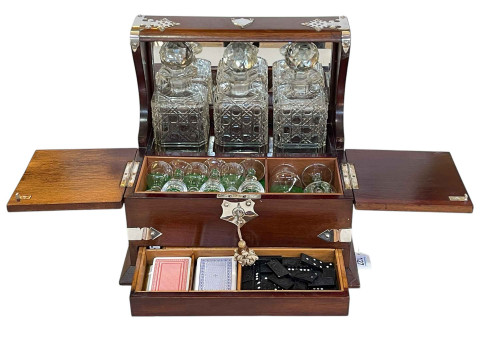 Mahogany table tantalus and games compendium with three bottles and eight...