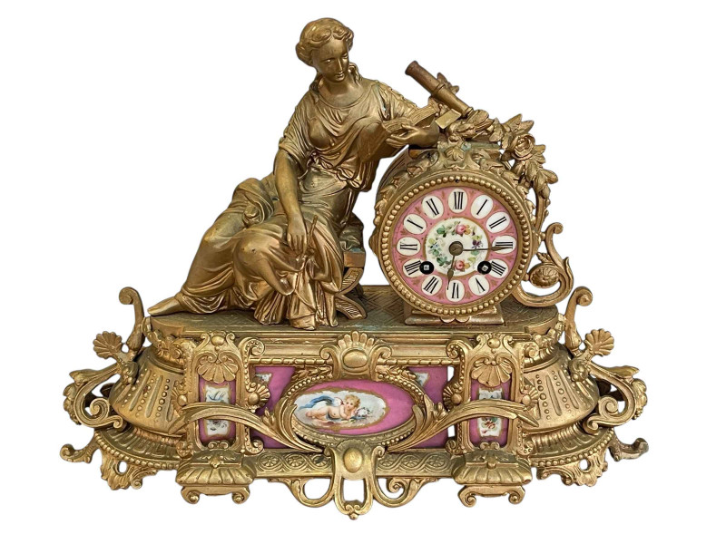 Ornate Continental gilt mantel clock decorated with pink porcelain panels and face.