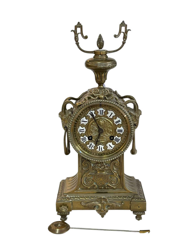 Ornate brass mantel clock with enamel Roman numerals.