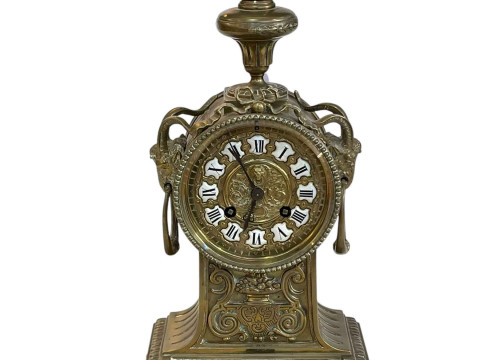 Ornate brass mantel clock with enamel Roman numerals.