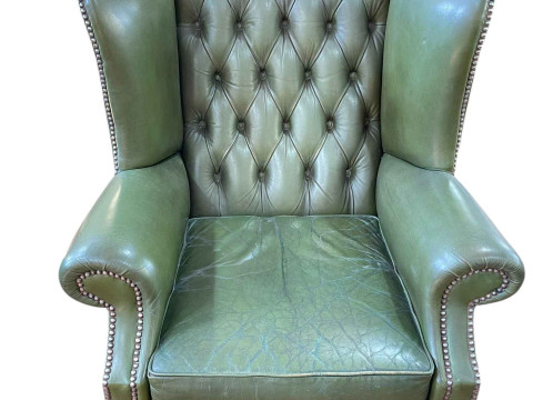 Green deep buttoned leather and studded wing back armchair on ball and...