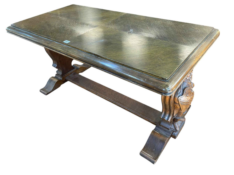 Rectangular oak coffee table raised on carved figural Knight supports joined by stretcher, 57cm by 116cm by 60cm.