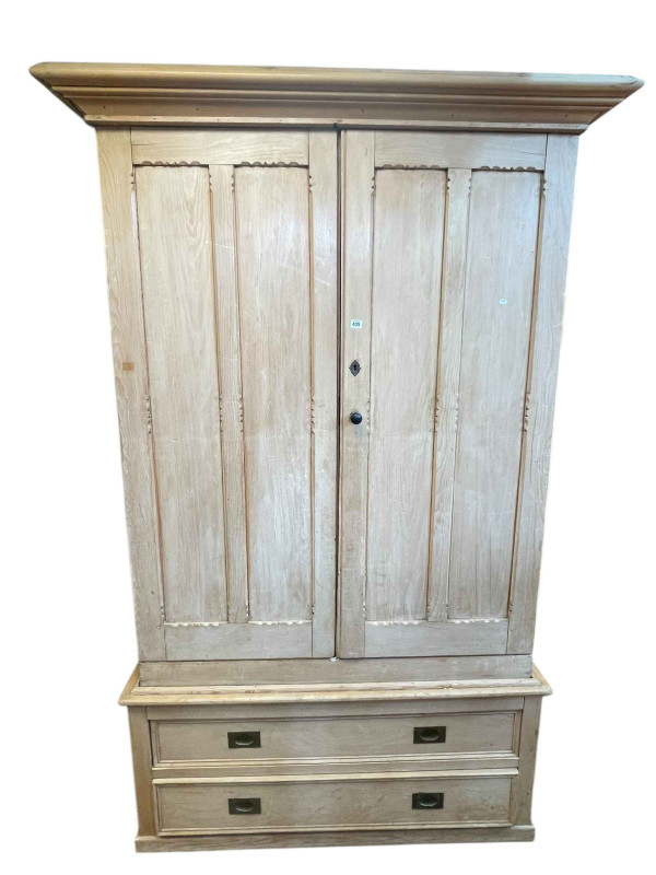 Victorian pine wardrobe having two doors enclosing five sliding trays above a base of two long drawers, 226cm by 141cm by 65cm.
