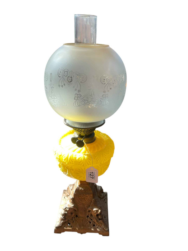 Victorian cast base oil lamp with yellow glass reservoir and frosted and etched glass shade.