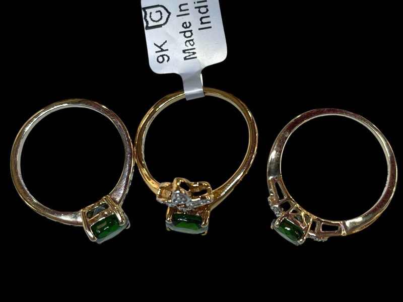 Three 9 carat gold and green gemstone rings.