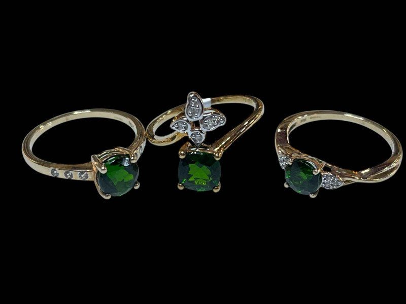 Three 9 carat gold and green gemstone rings.