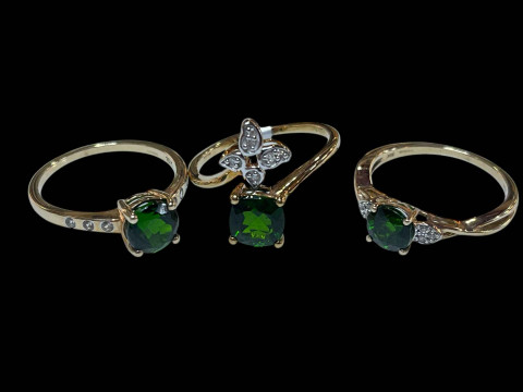 Three 9 carat gold and green gemstone rings.
