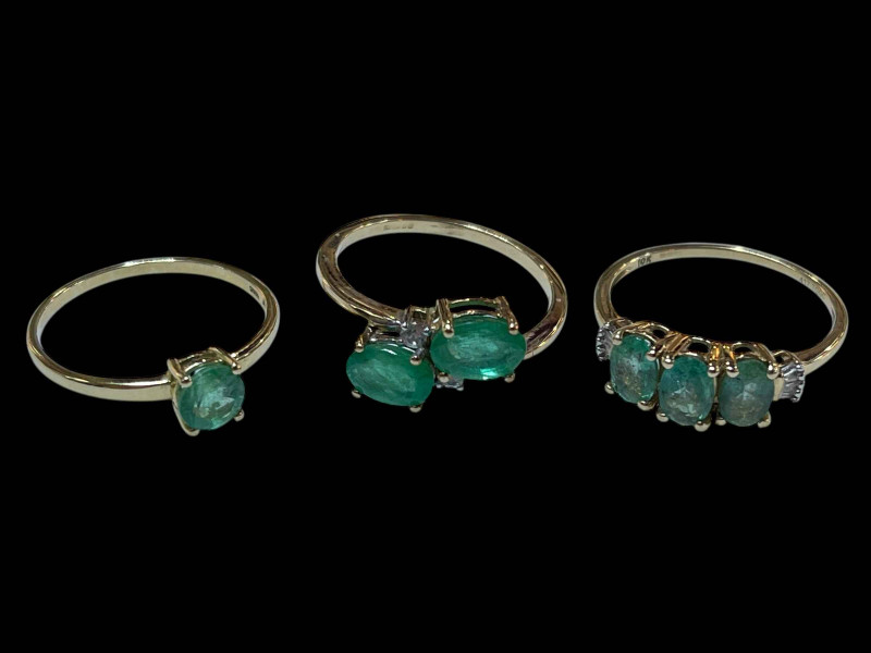 Three 9 carat gold and green gem set dress rings.