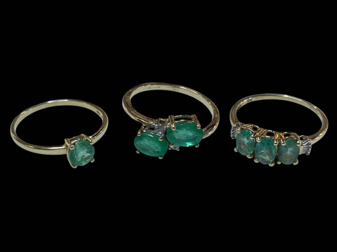 Three 9 carat gold and green gem set dress rings.
