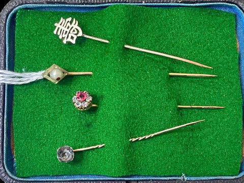 Four yellow gold stick pins.
