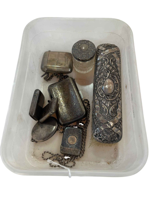 Silver cigarette case, four silver vestas, locket and chain, silver backed brush and toilet bottle.